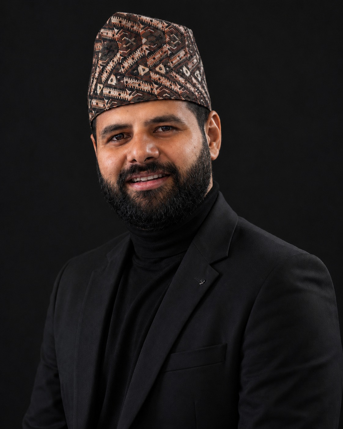 Portrait of Atlantic Bhandari, wearing a traditional Nepali dhaka topi and a black suit